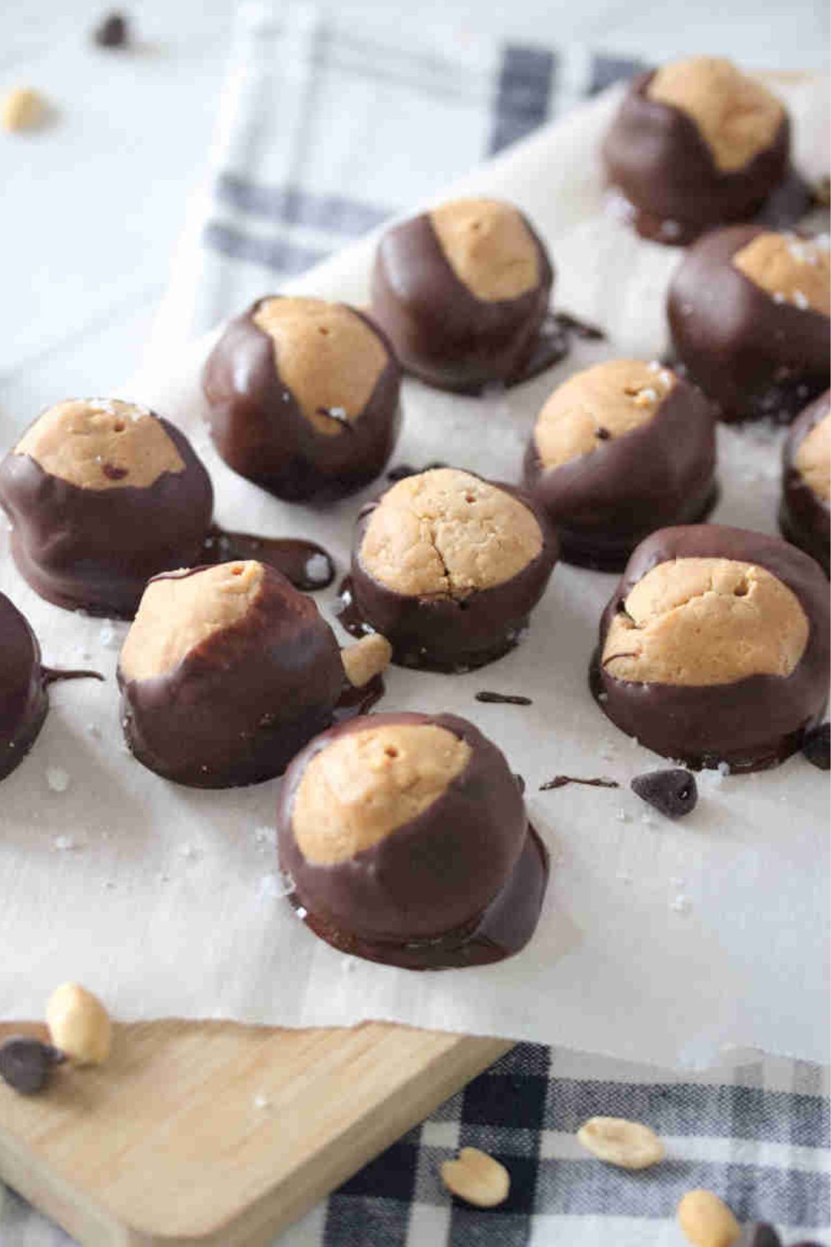A bunch of peanut butter buckeyes on top of a parchment paper.