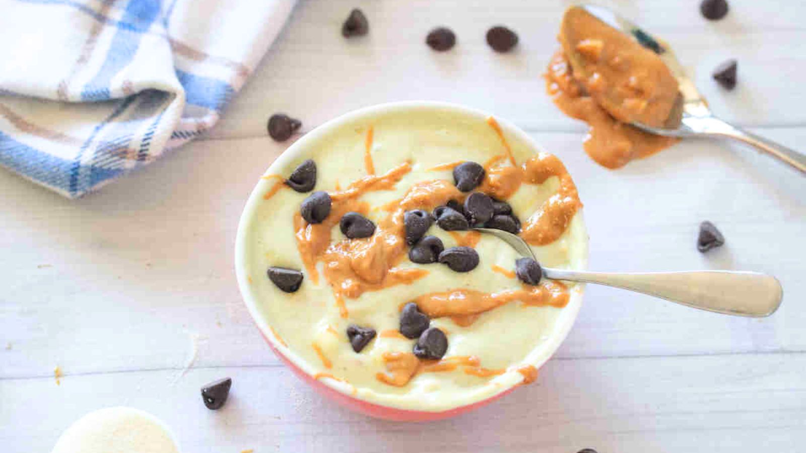 Yogurt protein pudding with peanut butter and chocolate chips in a bowl with spoon.