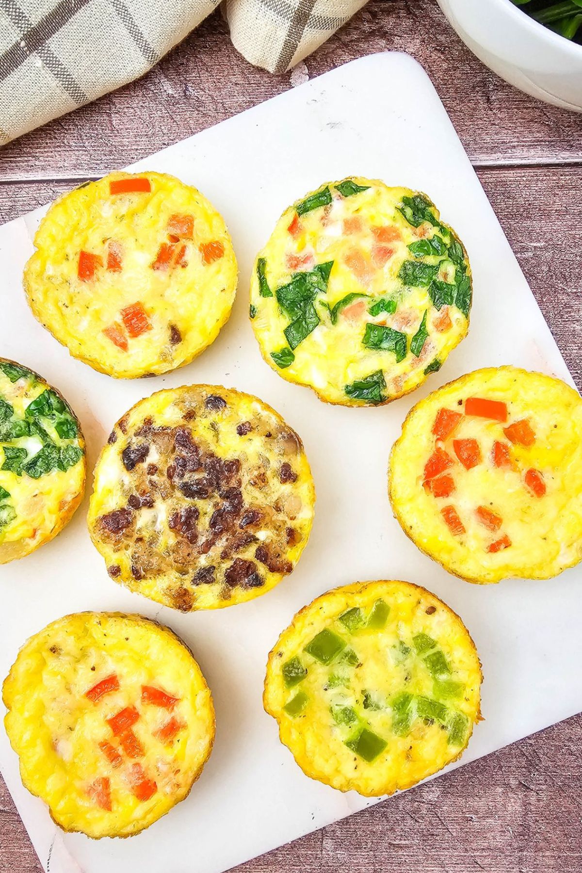 Mini dairy-free egg bites with bell peppers in them on a white plate.