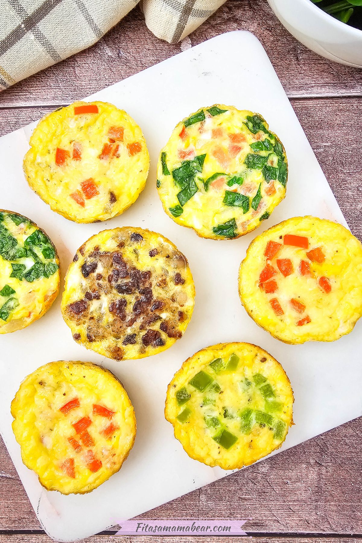 Mini dairy-free egg bites with bell peppers in them on a white plate.