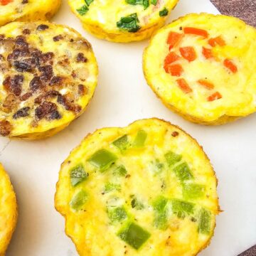 Mini dairy-free egg bites with bell peppers in them on a white plate.