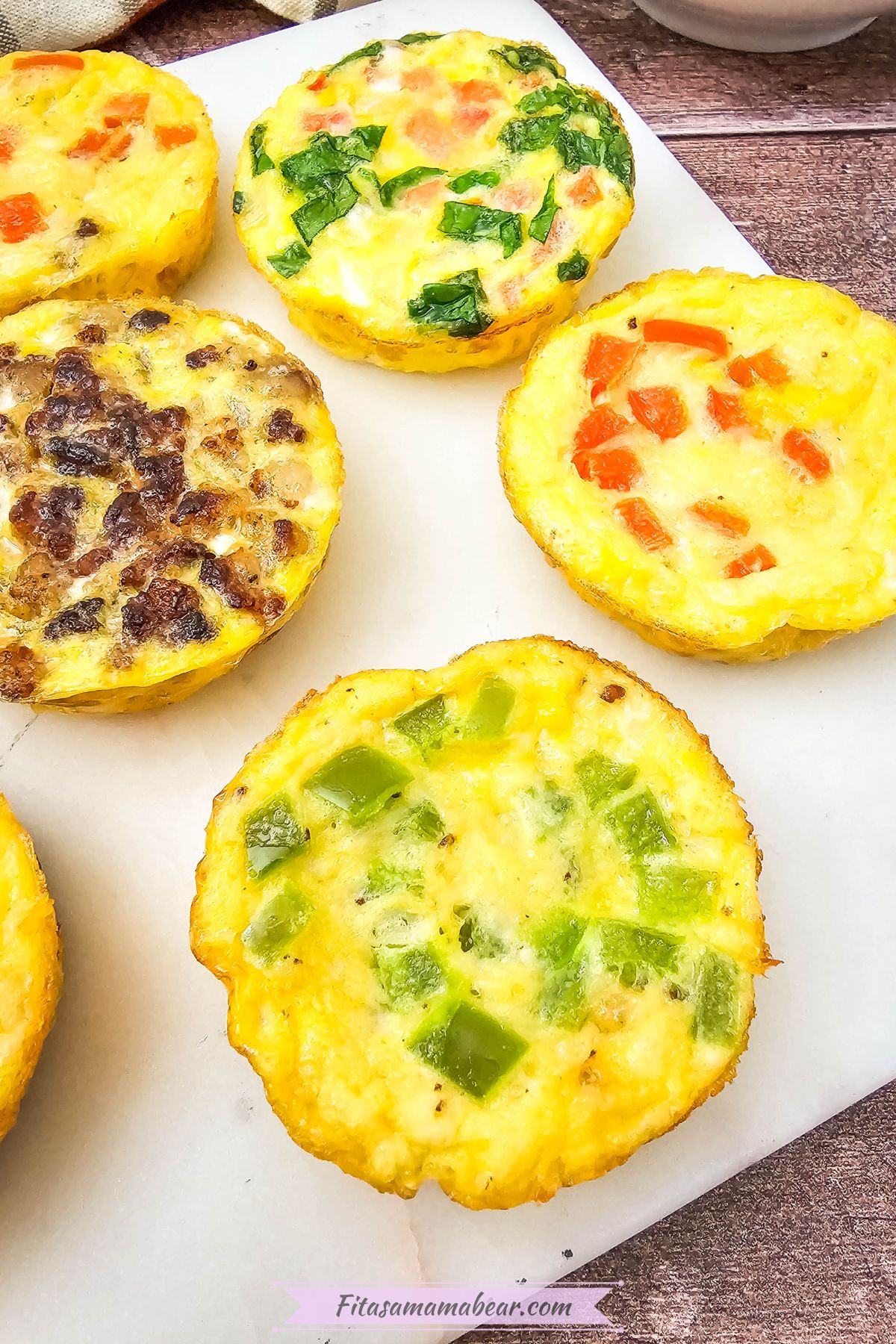 Mini dairy-free egg bites with bell peppers in them on a white plate.