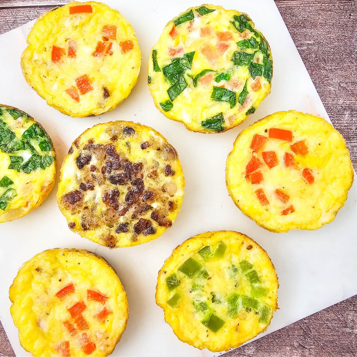 Mini dairy-free egg bites with bell peppers in them on a white plate.