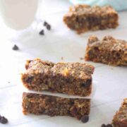Two grain-free granola bars stacked on one another with more bars beside them.