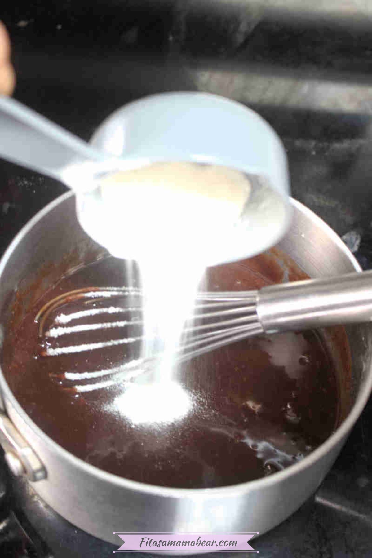 Collagen powder being added into a small pot of chocolate with a whisk.