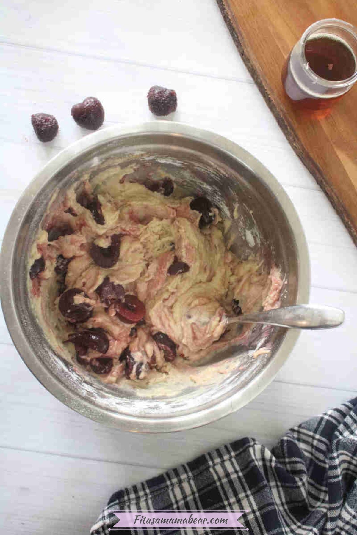 Steel bowl with raw batter for cherry muffin tops.