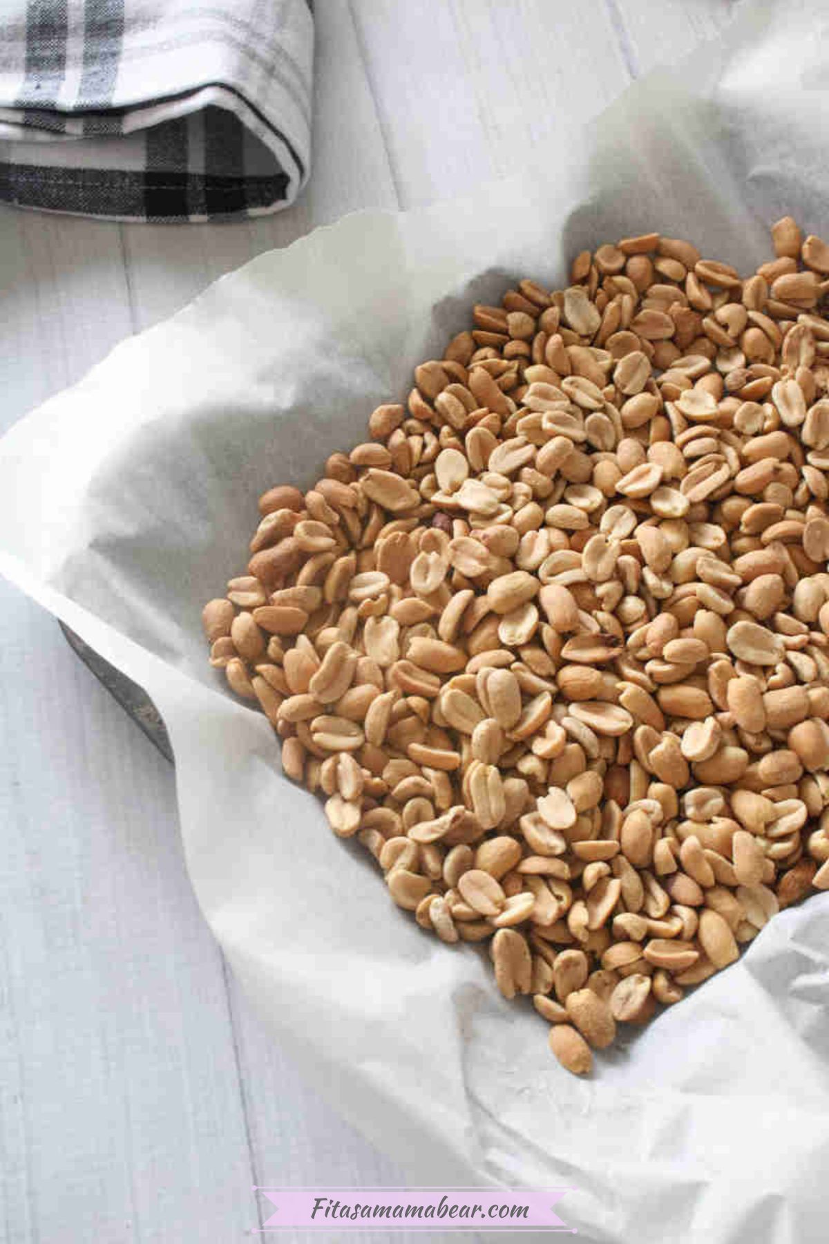Roasted peanuts on baking sheet with parchment paper.