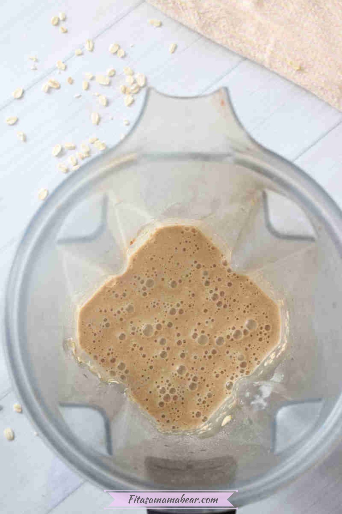 A blender with blended eggs, maple sryup, vanilla, oats, collagen powder, cinnamon, applesauce, and baking powder.