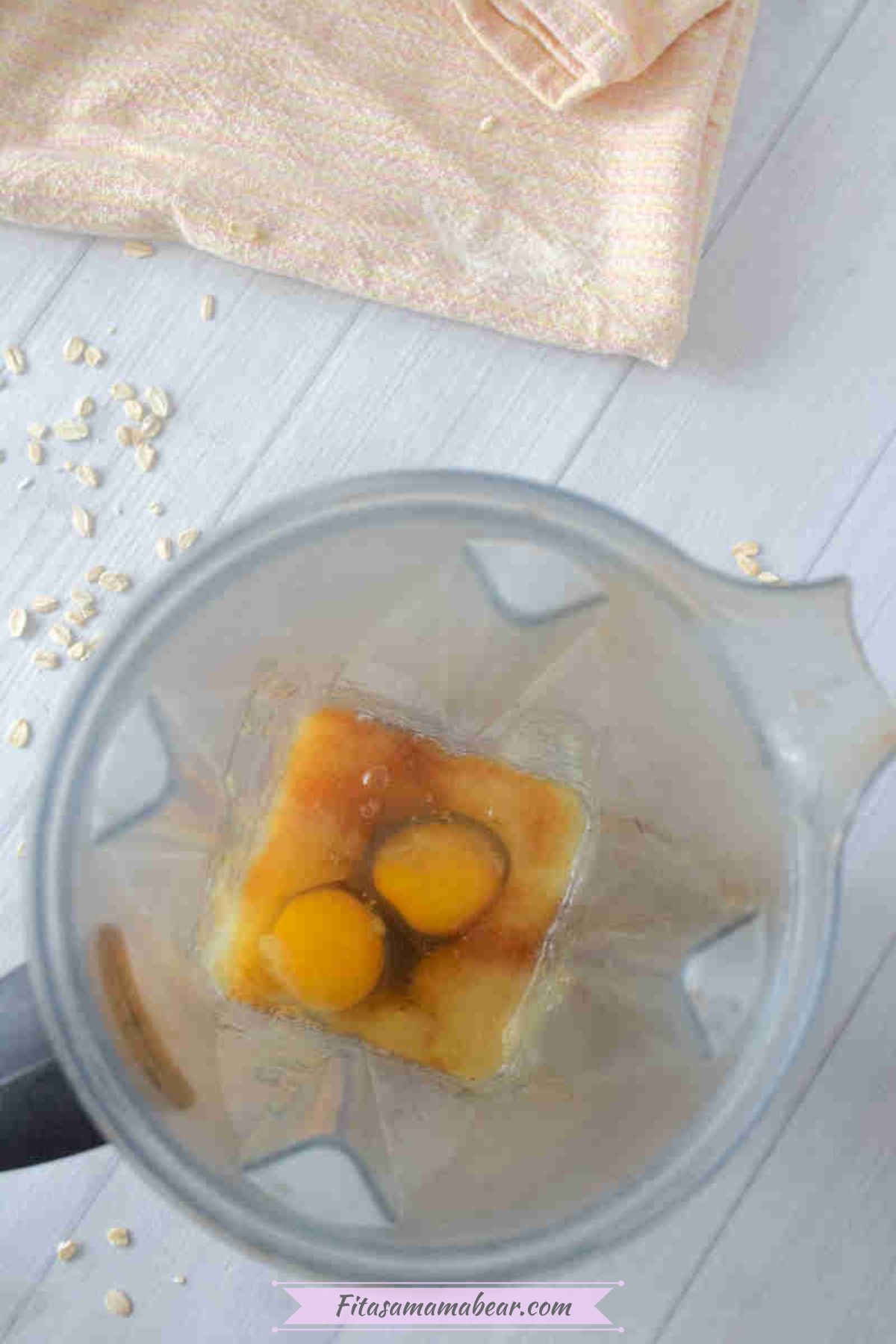 A blender with eggs, vanilla, maple syrup in it.