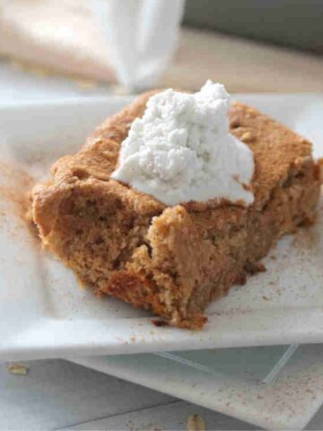 A plate of low calorie baked oats with coconut milk cream on top.