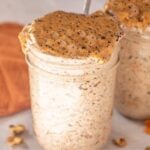 Mason jar with carrot cake overnight oats topped with nut butter and chia seeds.