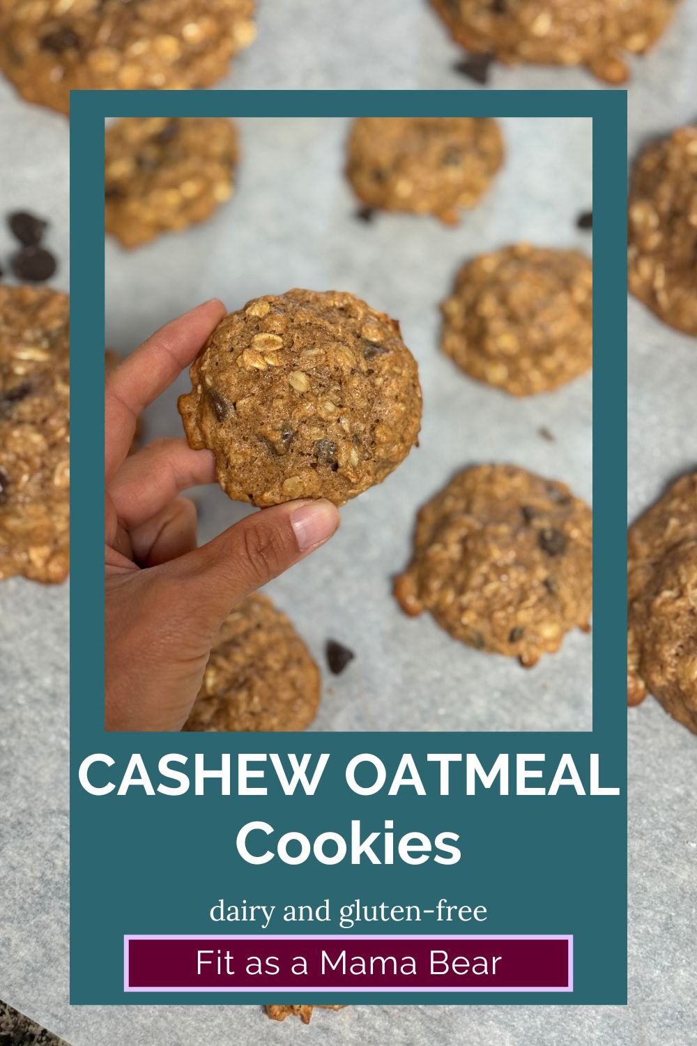 Two fingers holding up a cashew oatmeal cookie with more around it on parchment paper with text on the image.
