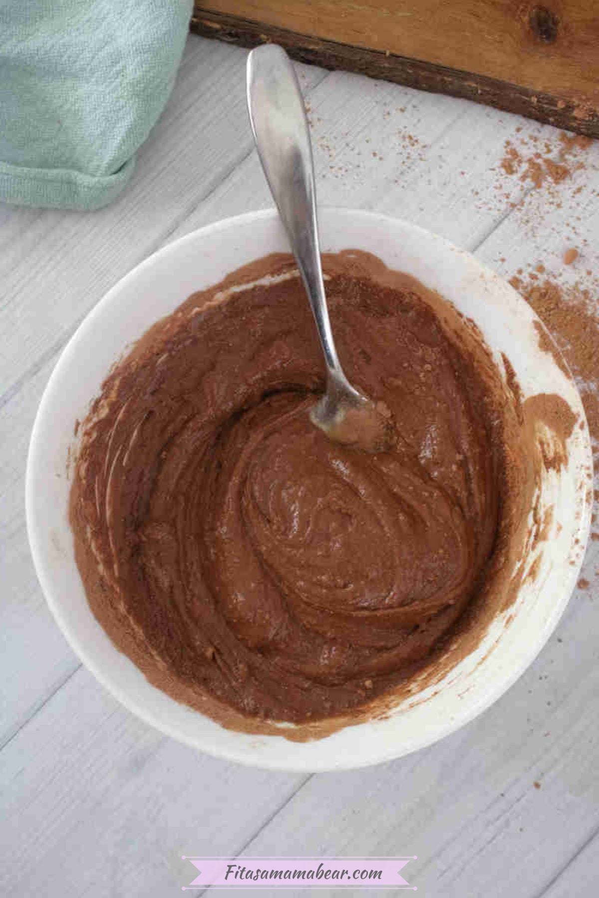 Mixed ingredients in a white bowl with a spoon.