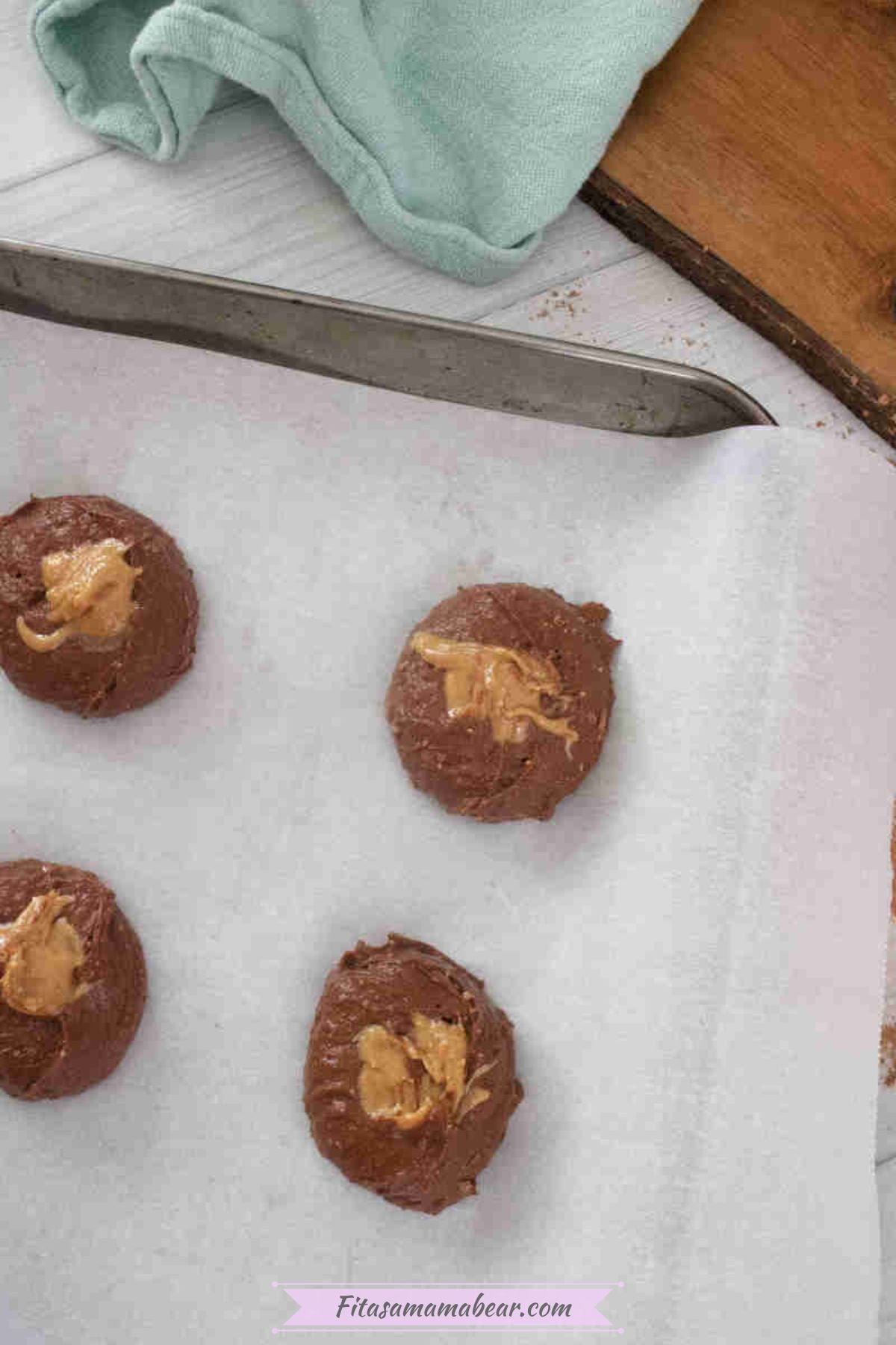 Baked double chocolate yogurt cookies with peanut butter toppings on a baking sheet.