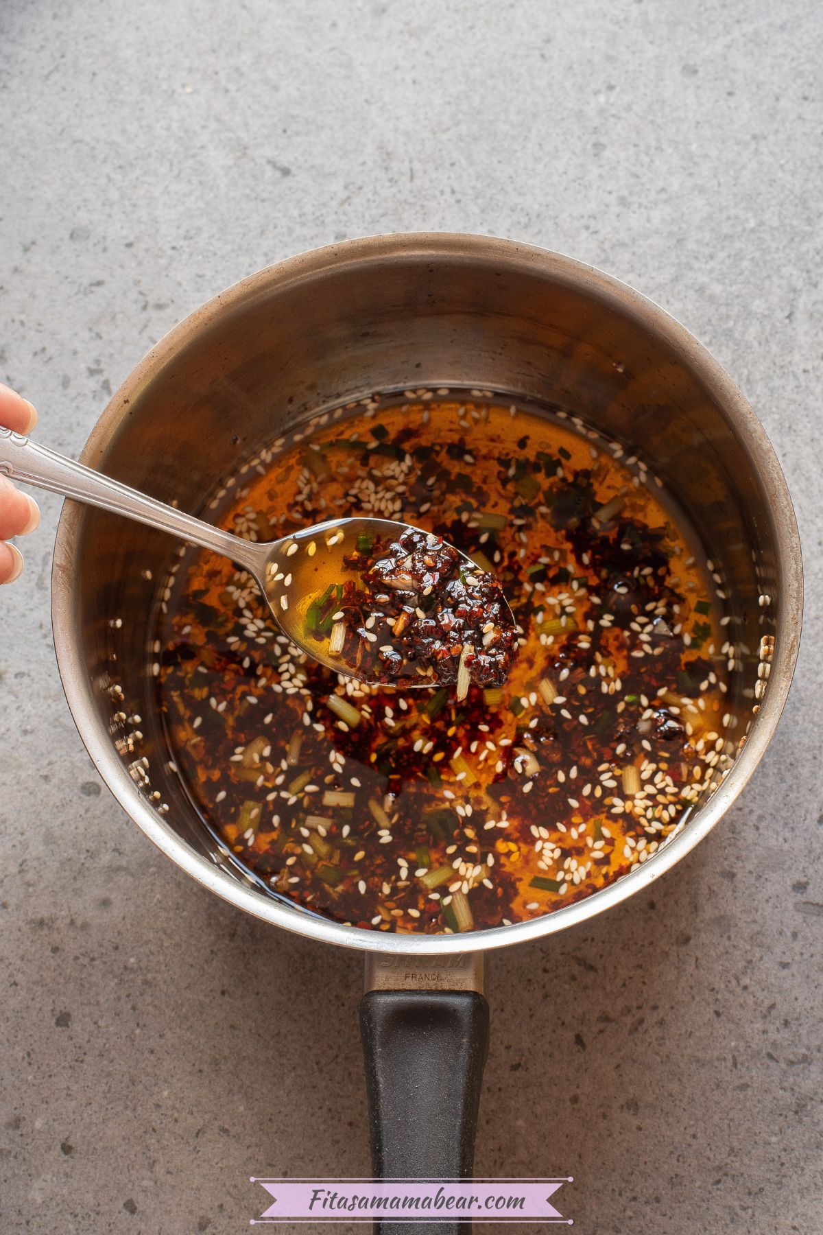 Chili flakes, soy sauce, sugar, and salt being mixed into sauteed ingredients.