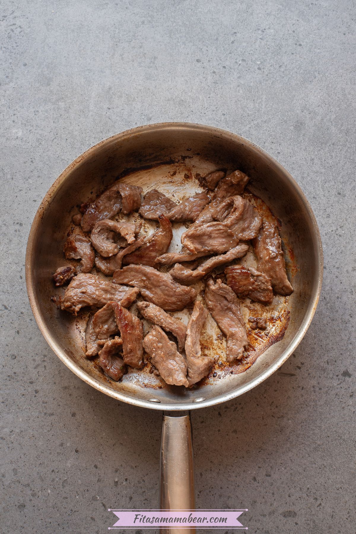 Beef strips seared in a pan.