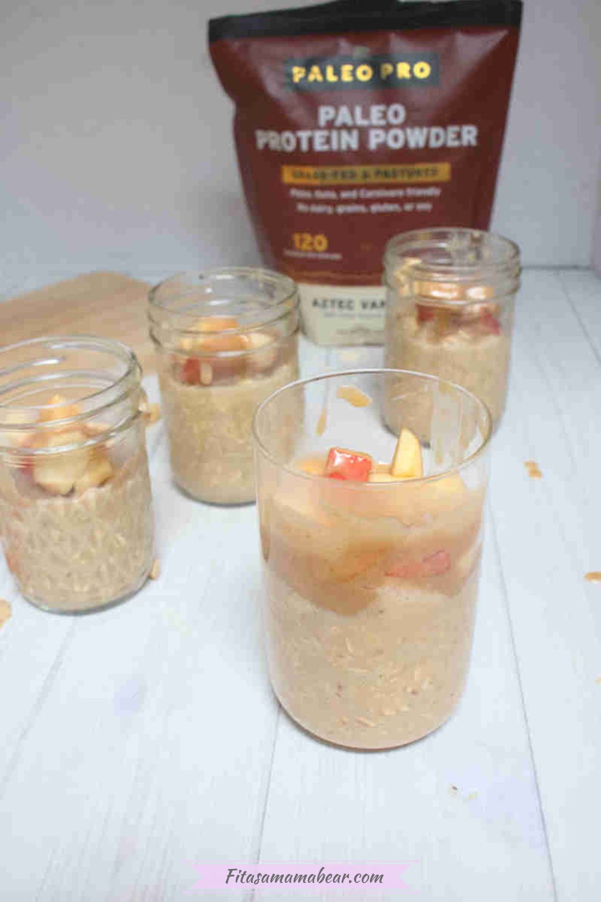 Jars filled with apple overnight oats topped with homemade caramel and more apples in the jars.