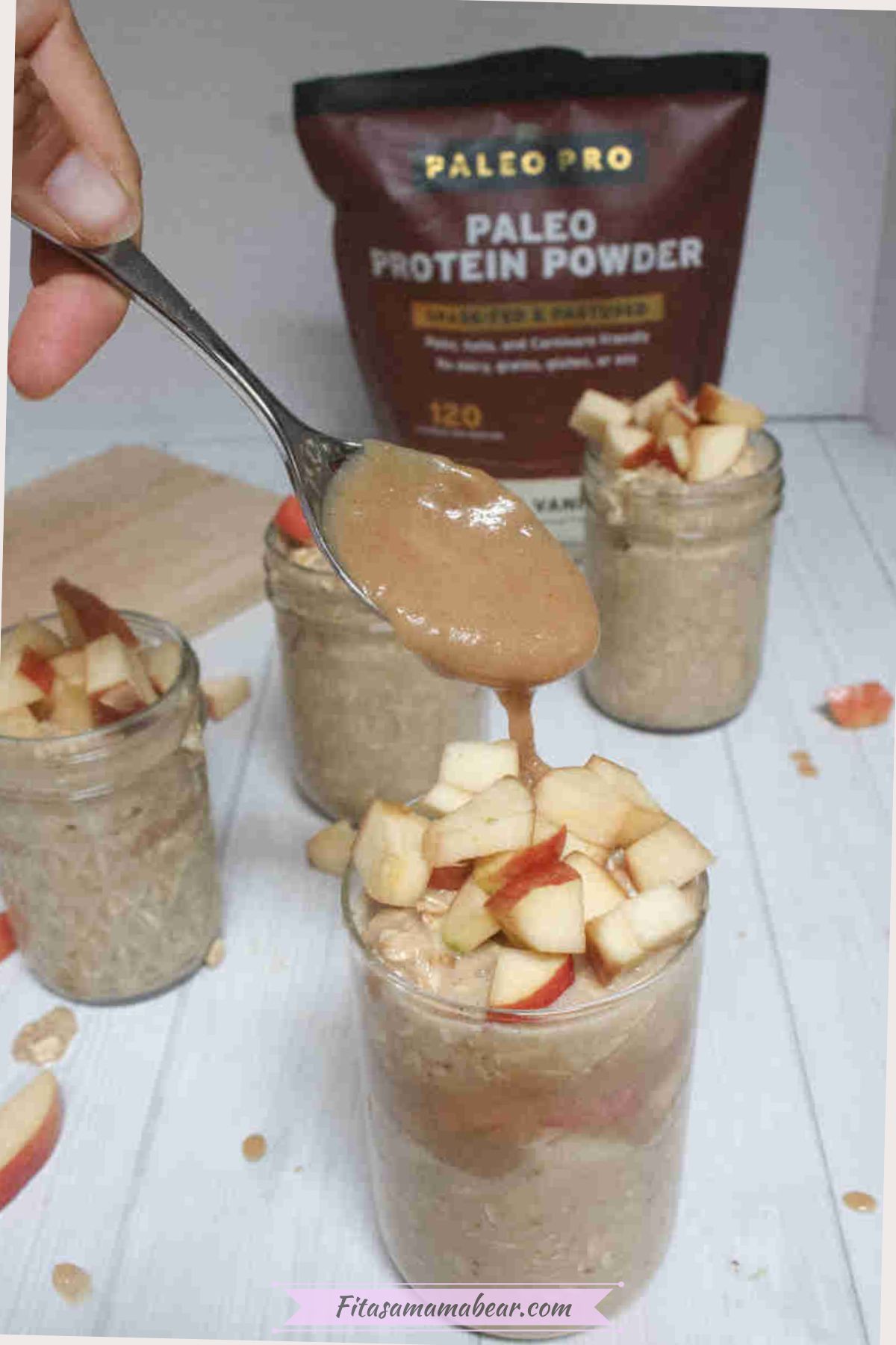 Homemade protein caramel being drizzled onto a jar filled with apple overnight oats and topped with chopped apples.