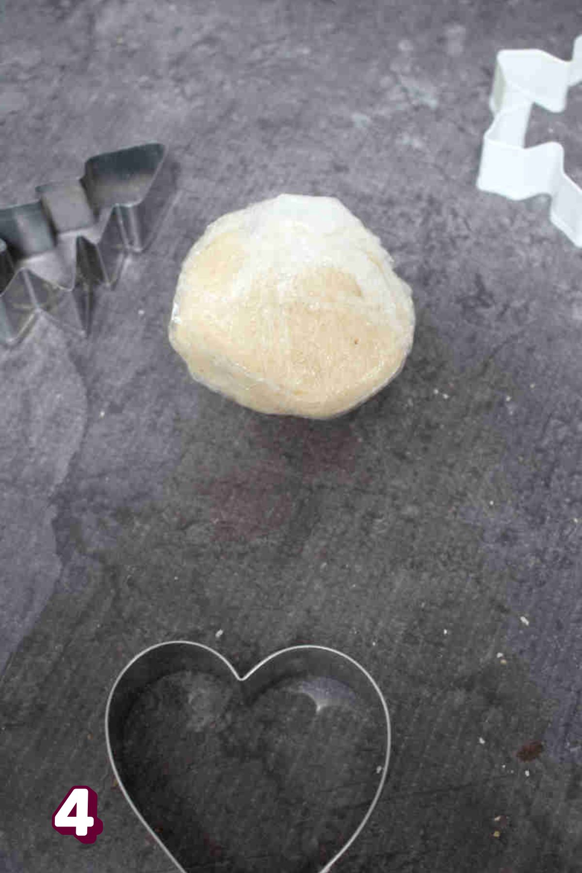 Ball of cookie dough wrapped in plastic wrap.