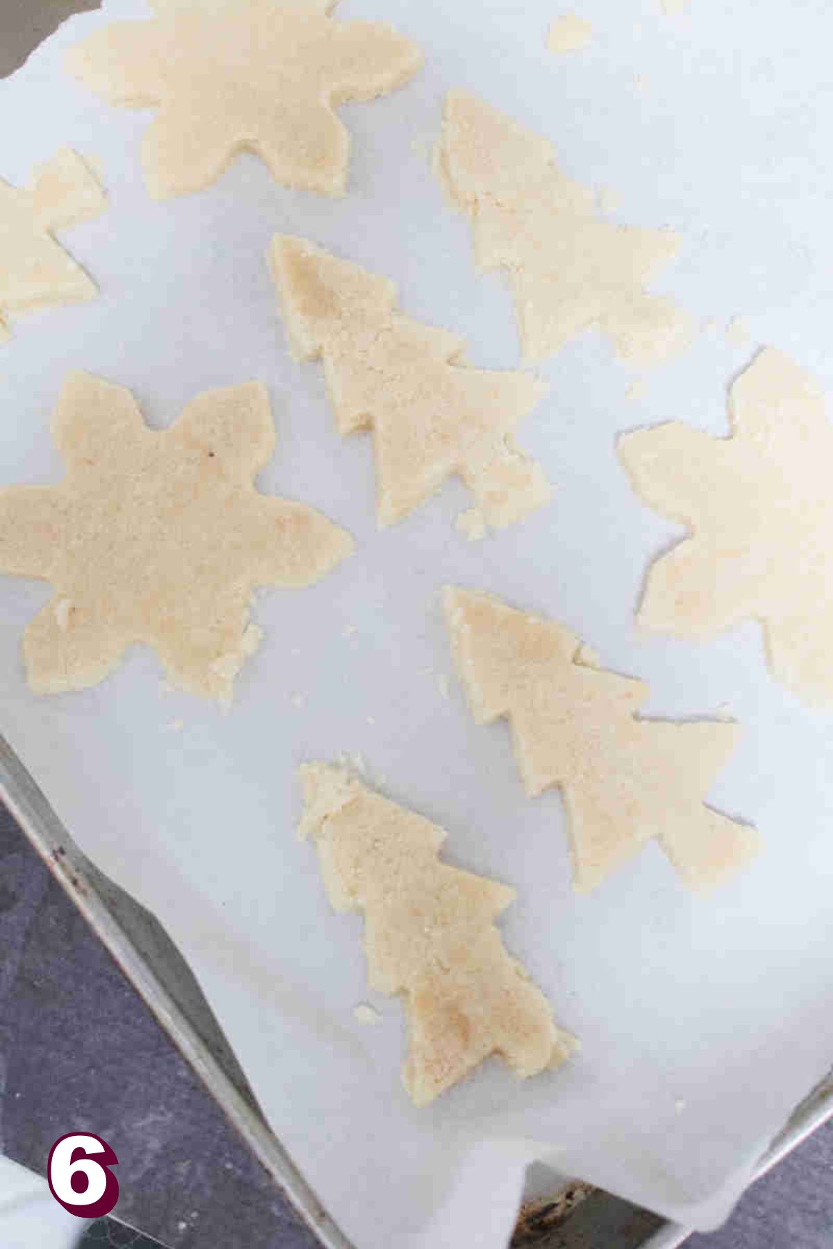 Almond flour sugar cookies in Christmas shapes on a baking tray.