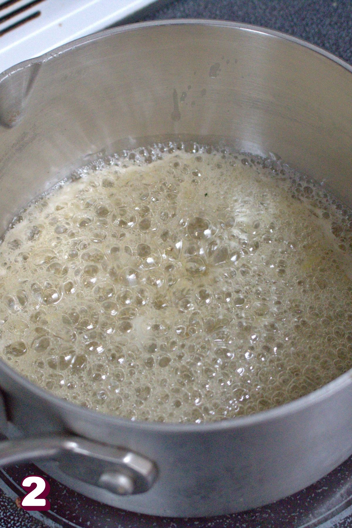 Honey boiling in a small pot on the stove.
