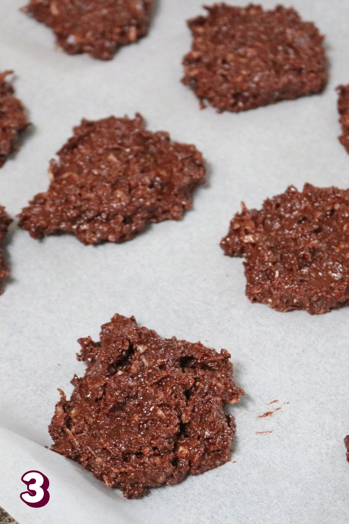 Chocolate coconut cookies uncooked on parchment paper.