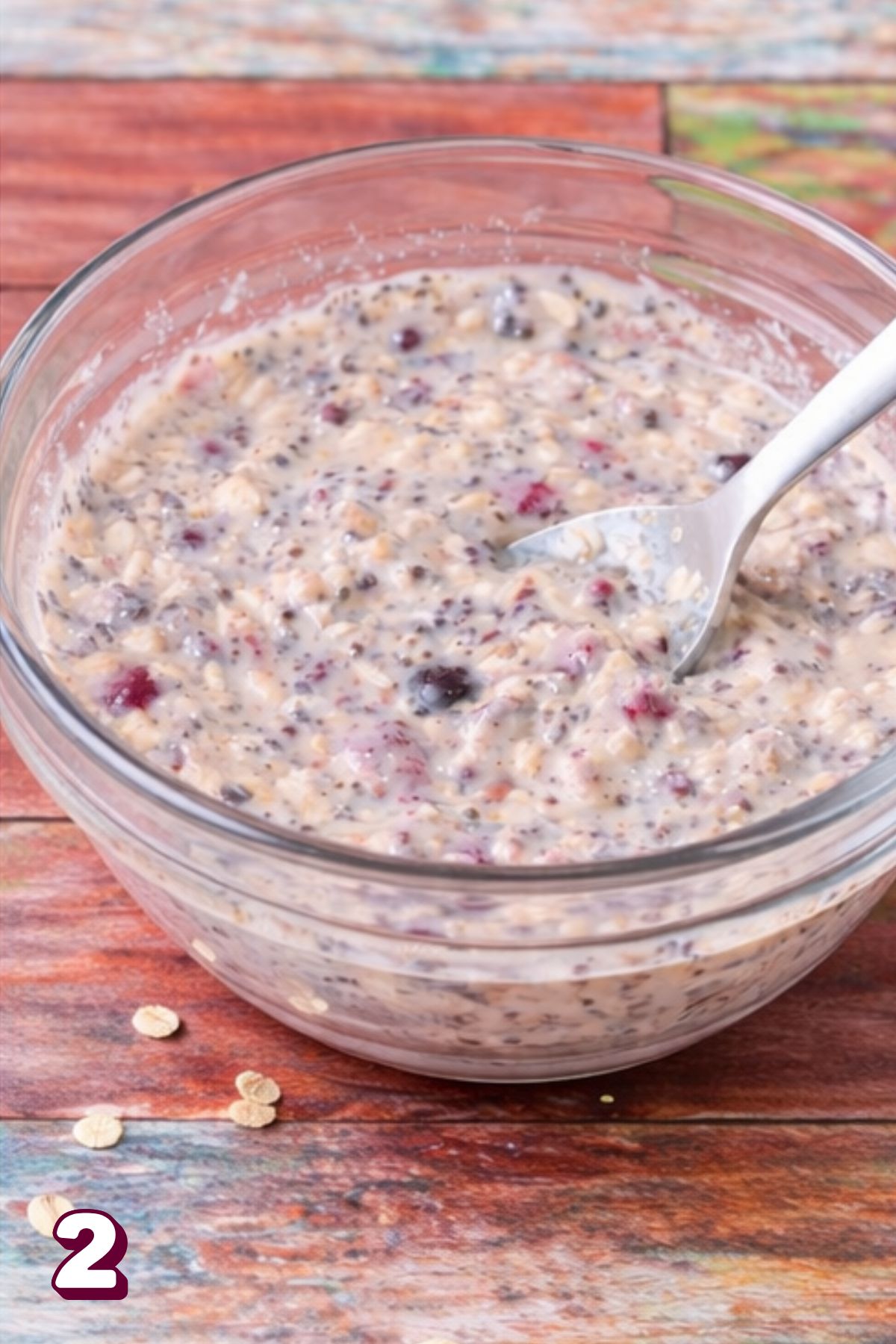 A glass bowl with dairy-free overnight oats with chia seeds and berries.