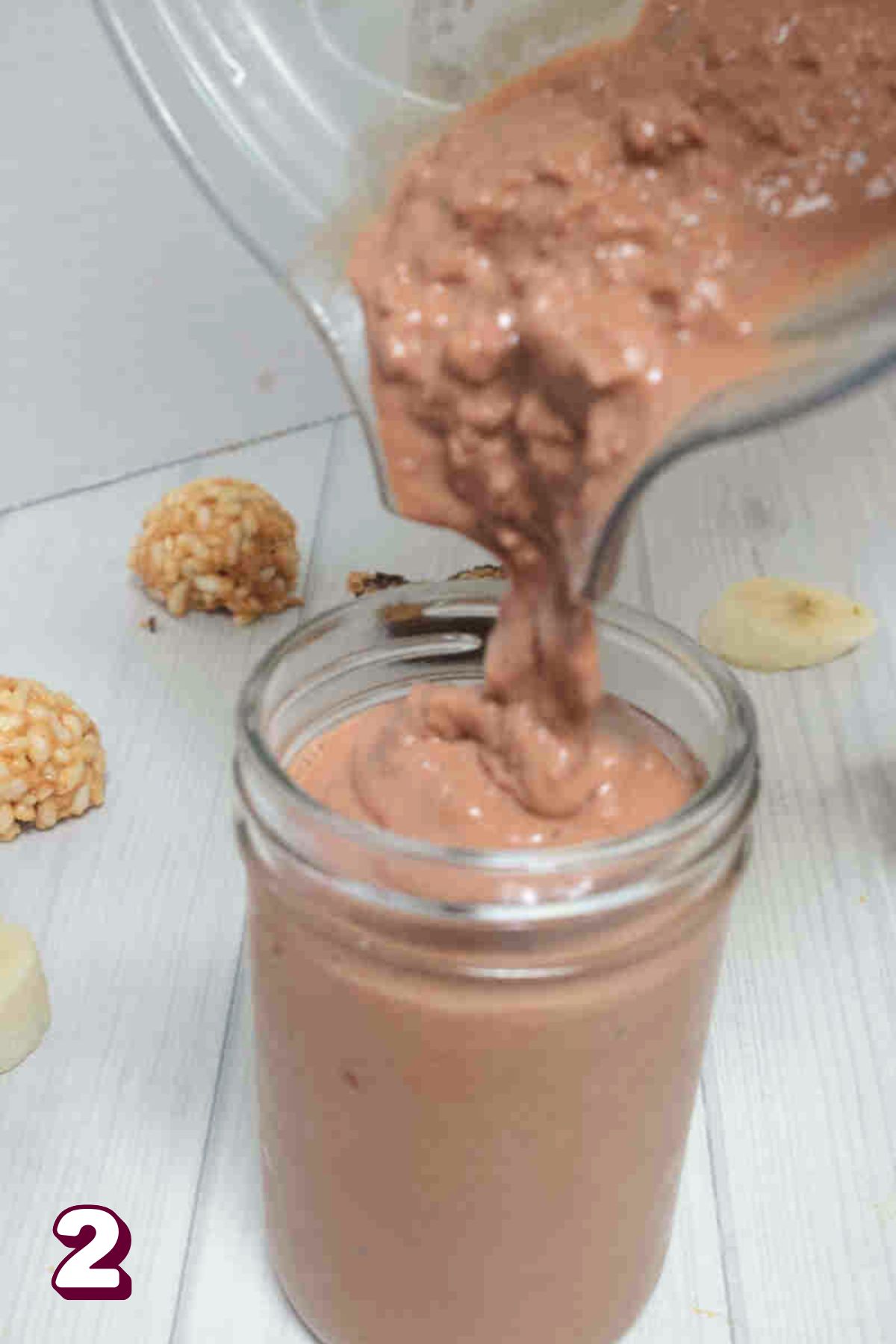 Chocolate peanut butter protein shake being poured into a mason jar.