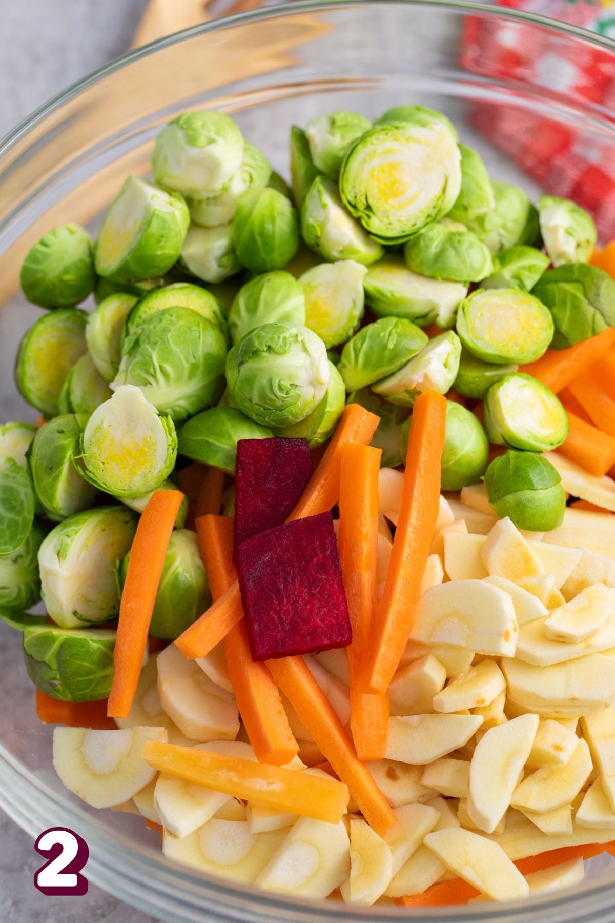 Brussels, carrots, and beets in a glass bowl.