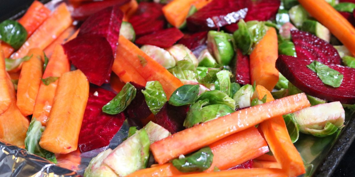 Brussels, carrots, and beets on a pan lined with tin foil.