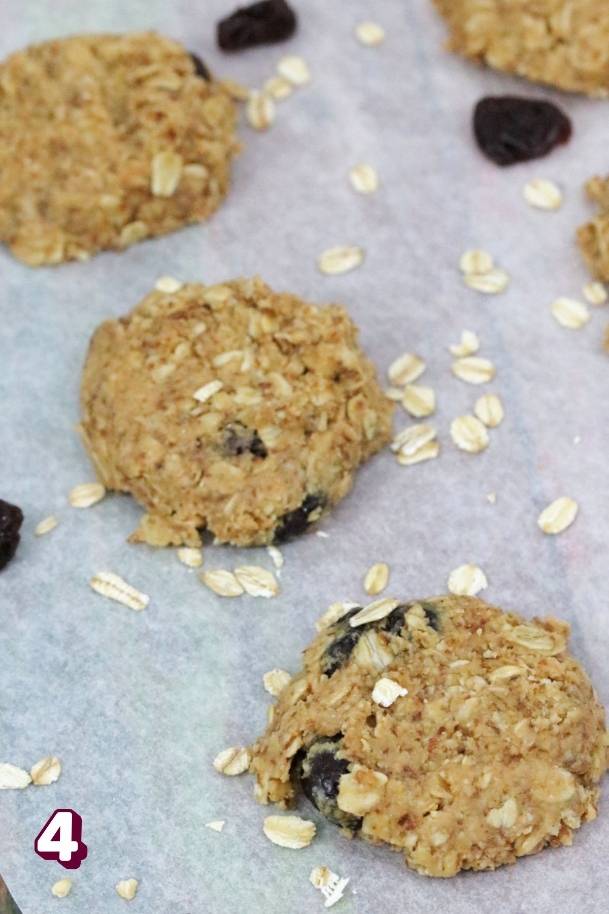 No-bake lactation cookies on parchment paper with oats around them.
