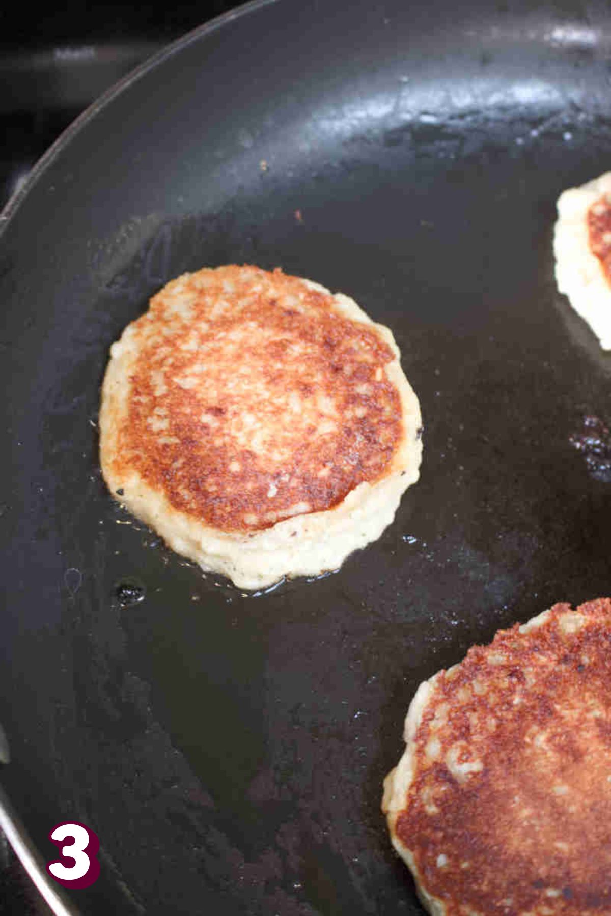 Almond flour oat pancakes cooking in a pan.