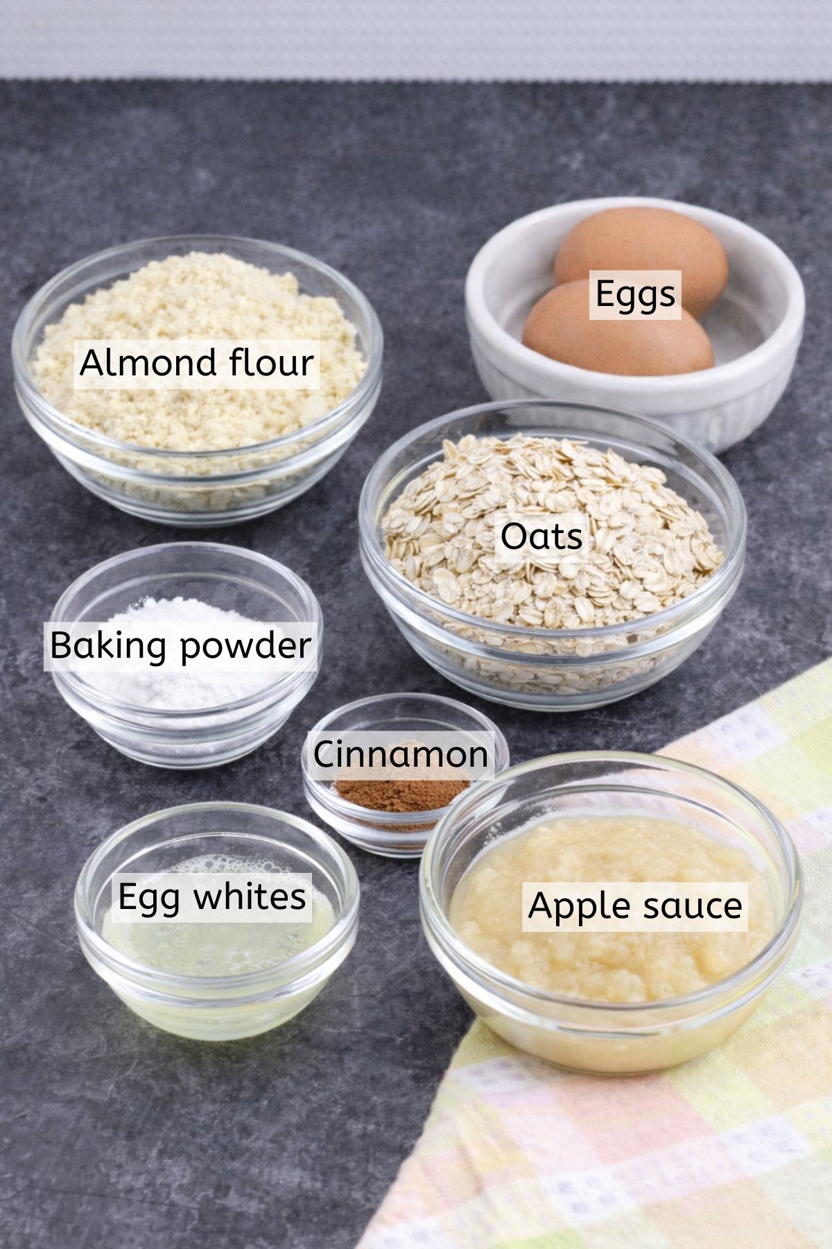 Oats, almond flour, and seasonings in glass bowls with text labels over top.