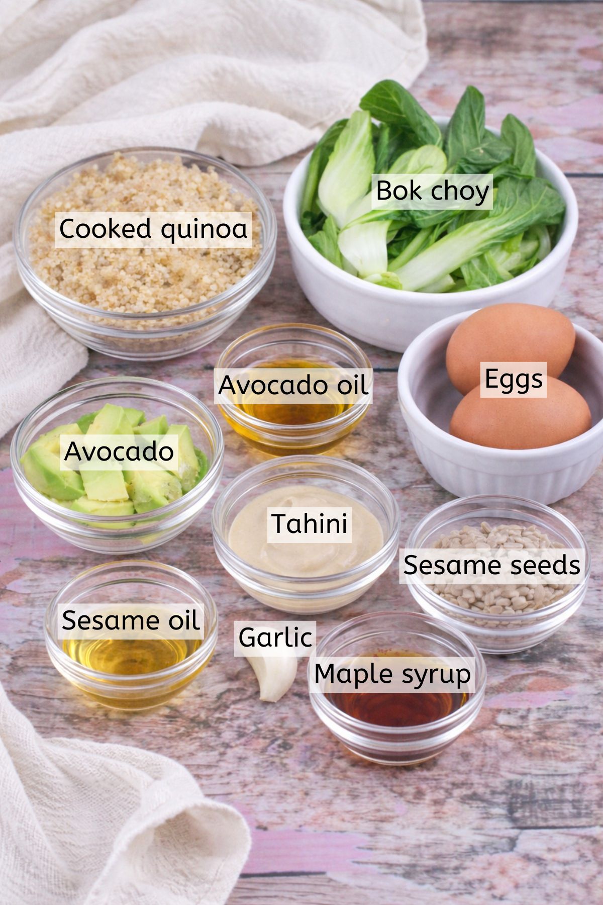 Cooked quinoa, bok choy, eggs, and dressings in glass bowls with text labels over top.