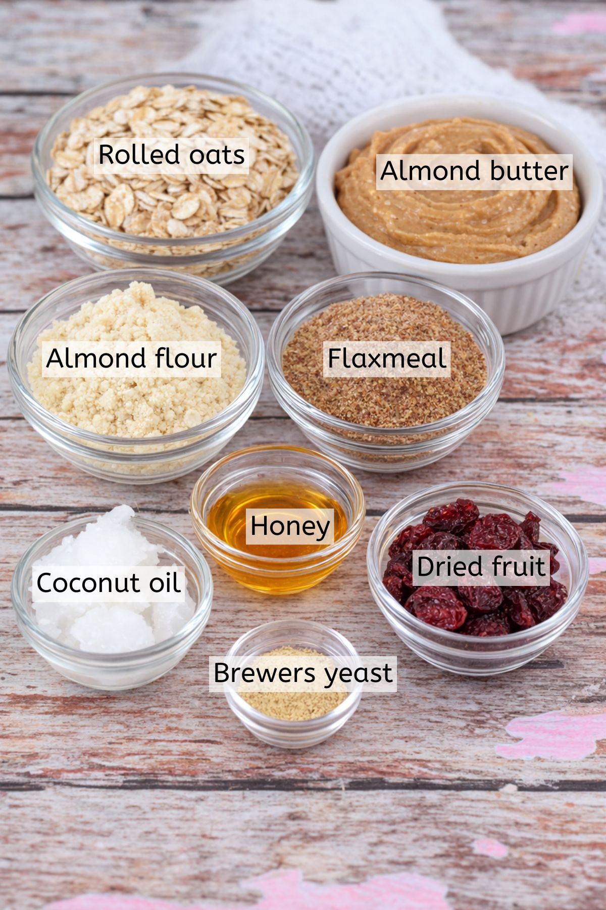Ingredients for no-bake lactation cookies in glass bowls with text labels over top.