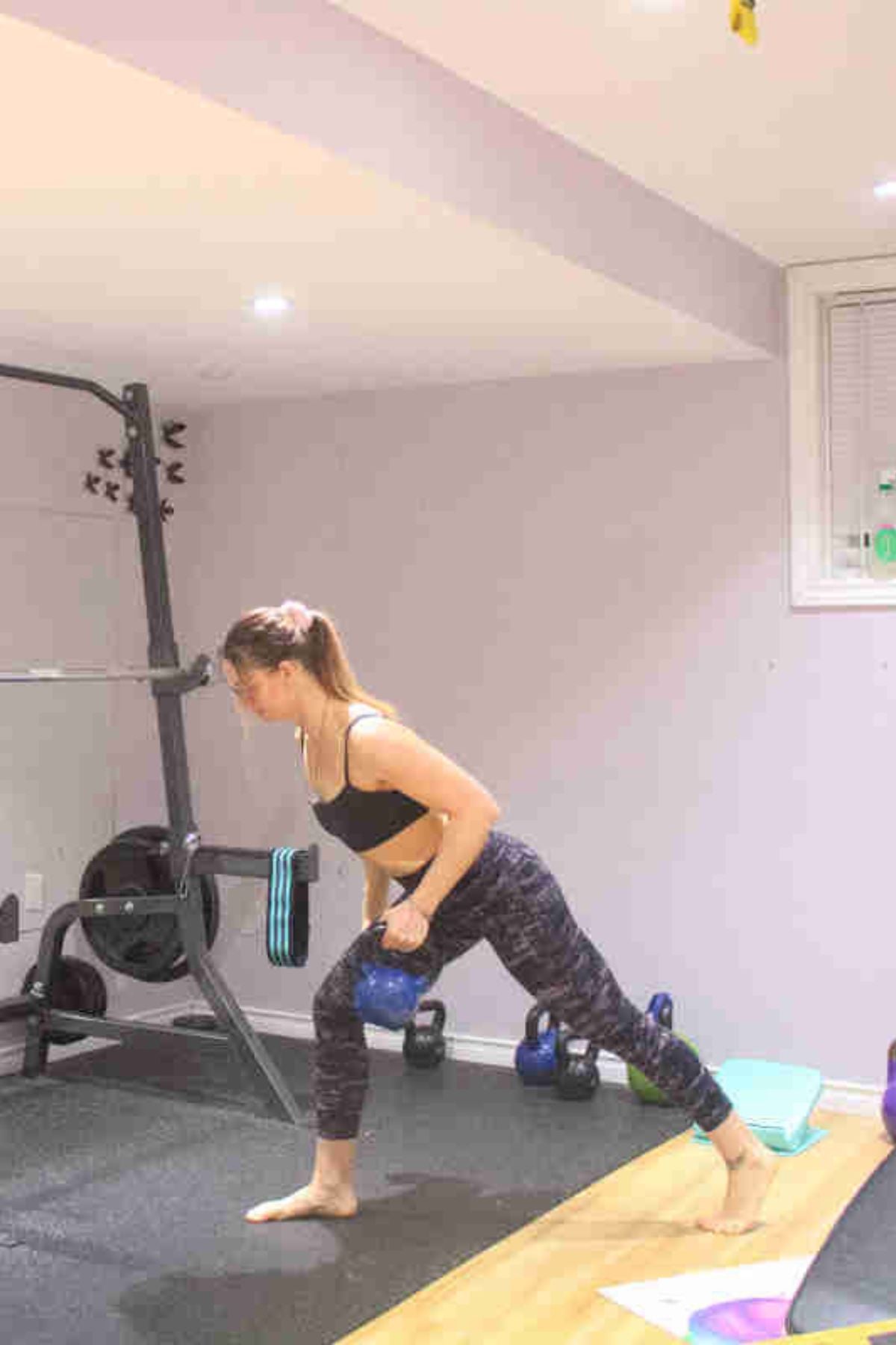 Woman performing a single arm row with a kettlebell.