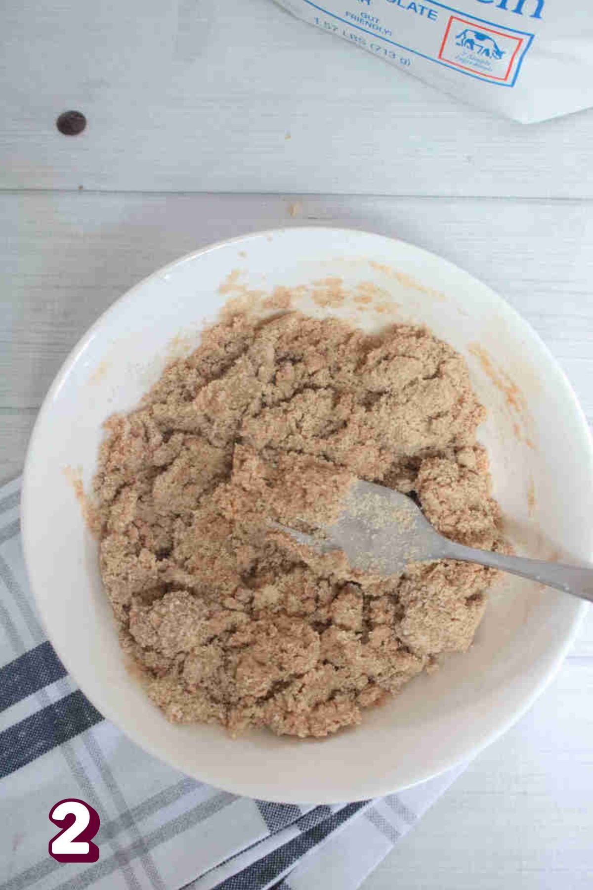 Raw cookie dough in a white bowl with a fork.