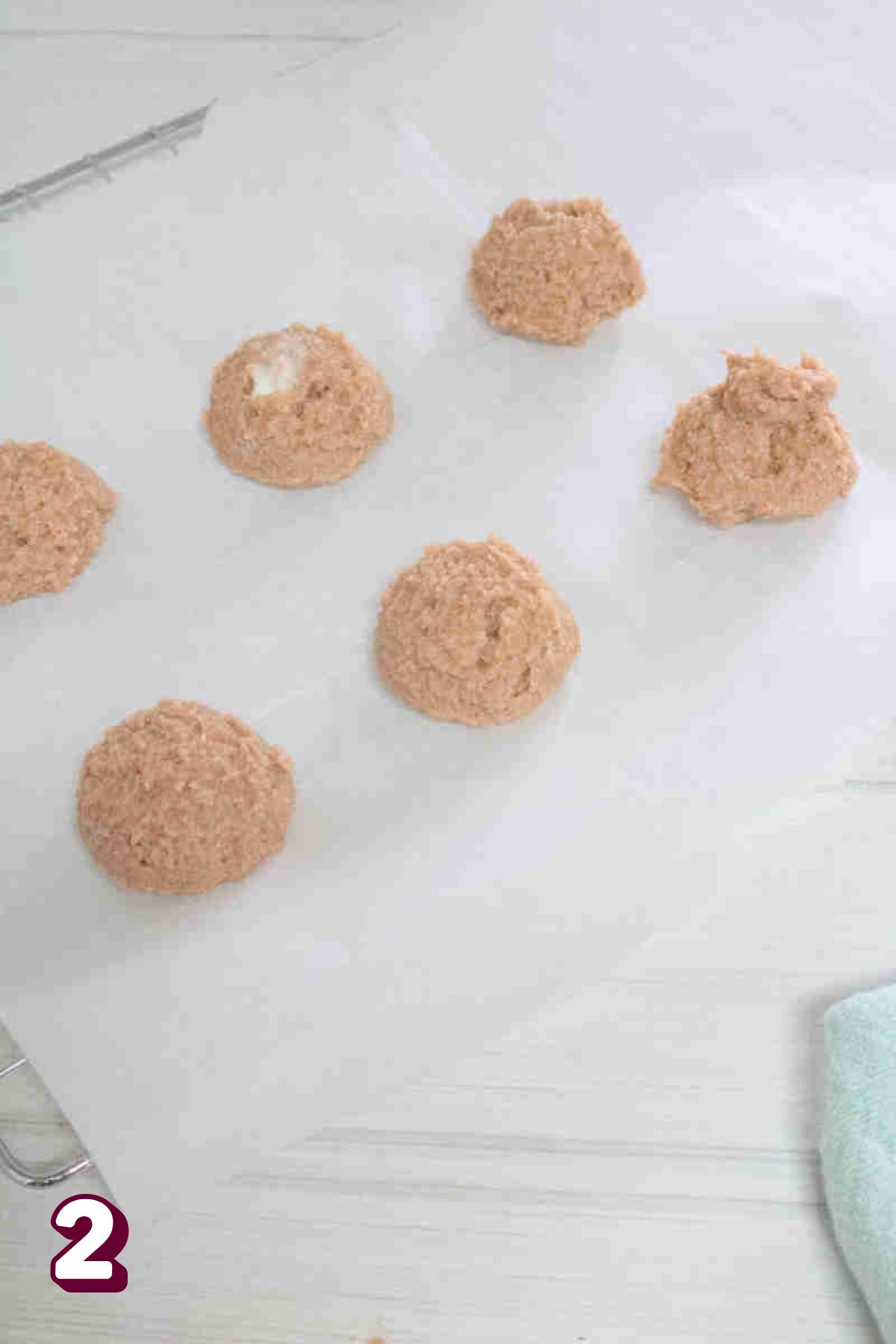 Raw cookie dough balls on parchment paper.