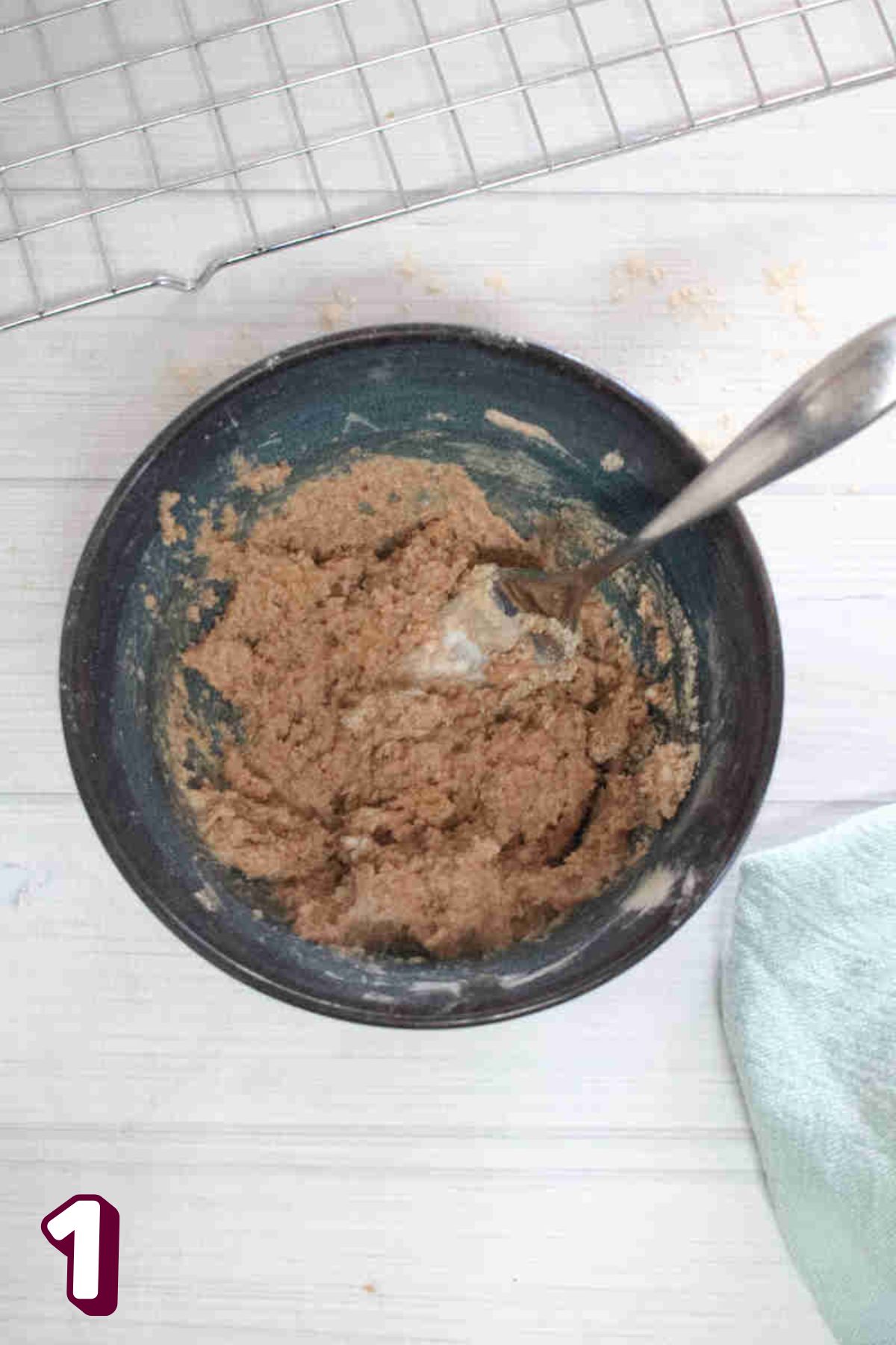 Blue bowl with raw cookie dough in it and a fork.