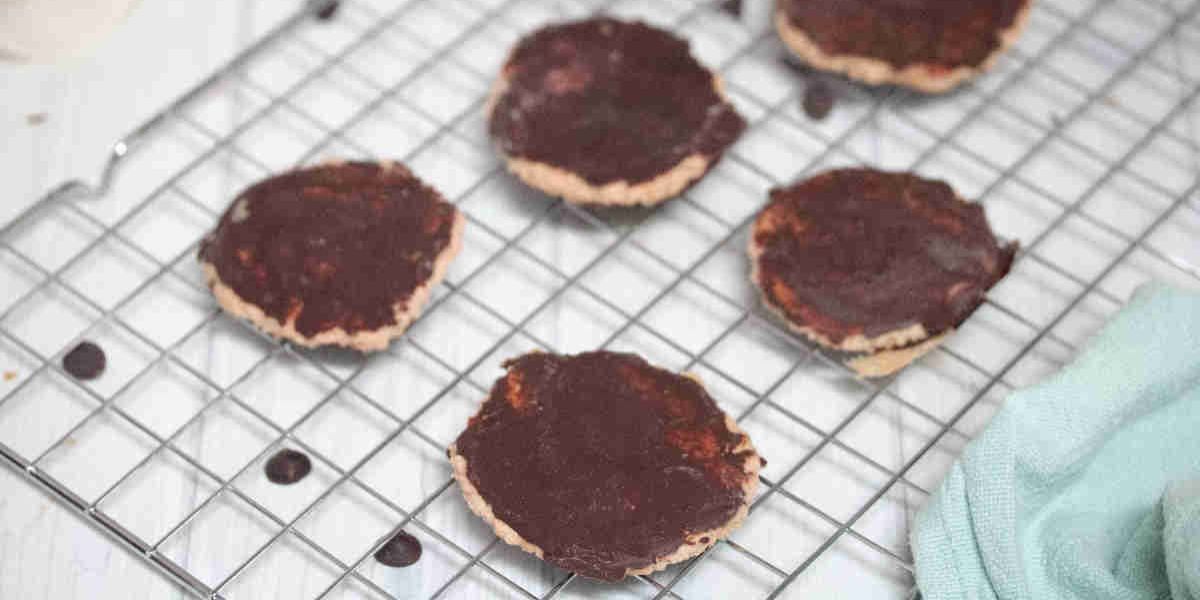 Chocolate coated protein thin mint cookies on a wire rack.