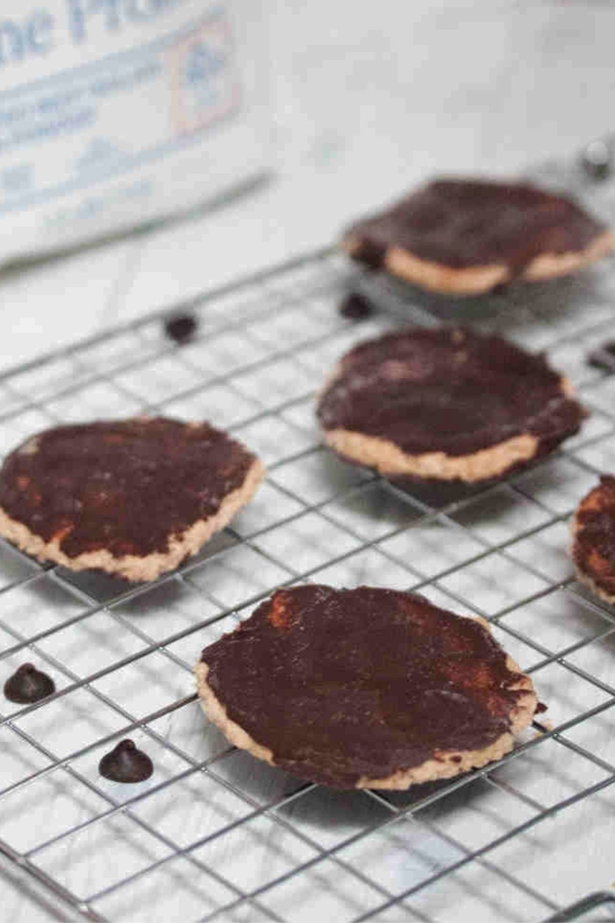 Chocolate coated protein thin mint cookies on a wire rack.