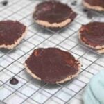 Chocolate coated protein thin mint cookies on a wire rack.