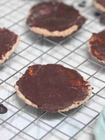 Chocolate coated protein thin mint cookies on a wire rack.