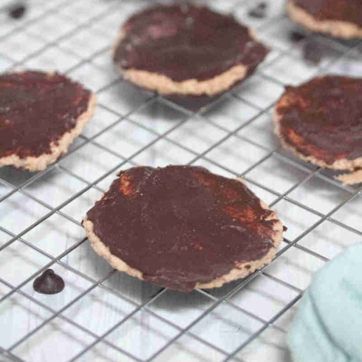 Chocolate coated protein thin mint cookies on a wire rack.
