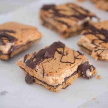 frozen smores with chocolate drizzle on top of a parchment paper