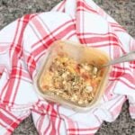 Protein apple crumble with oat topped in a single serve ramekin on top of a red linen.