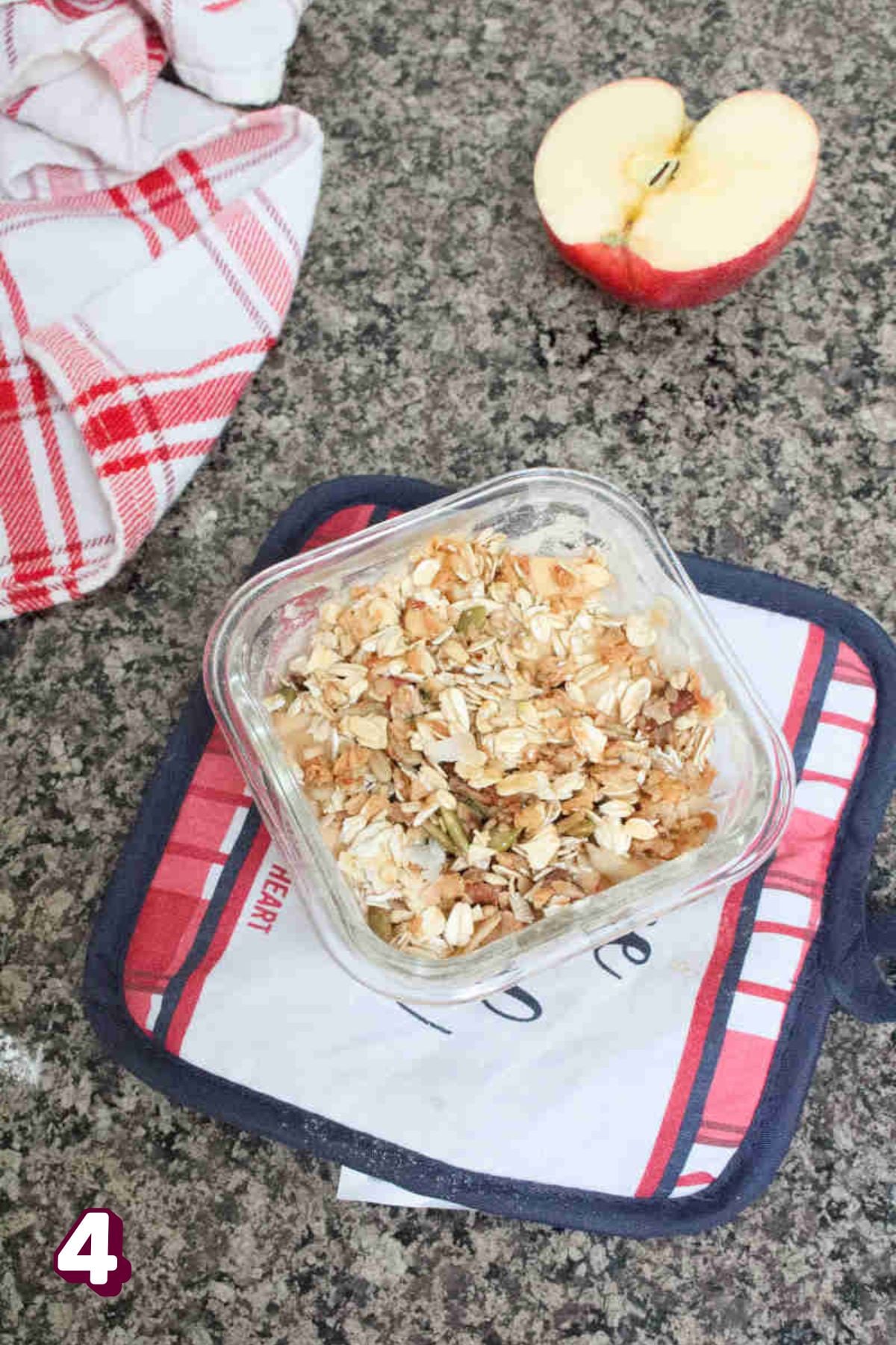 Uncooked single serve apple protein crumble on a hot pad with an apple behind it.