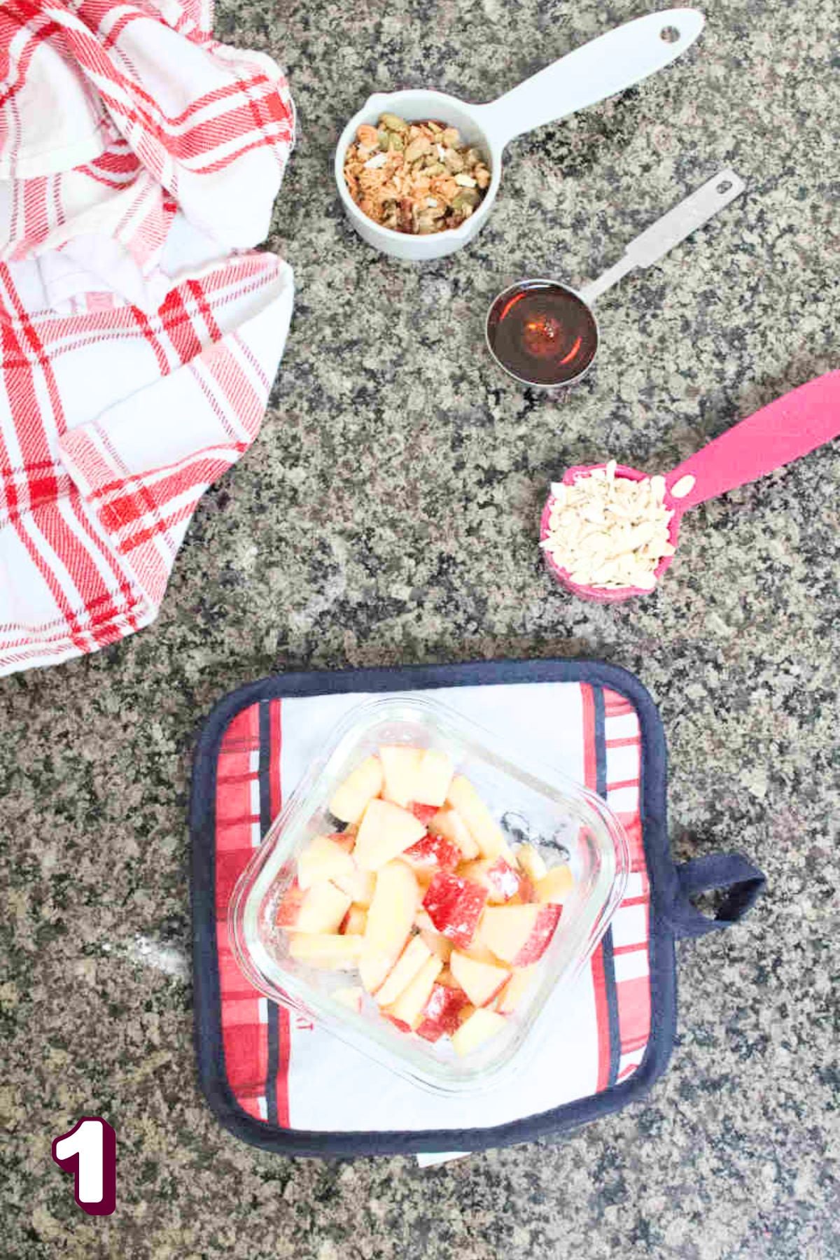 Small glass ramekin with chopped apples and arrowroot powder on a red and blue cooling pad.