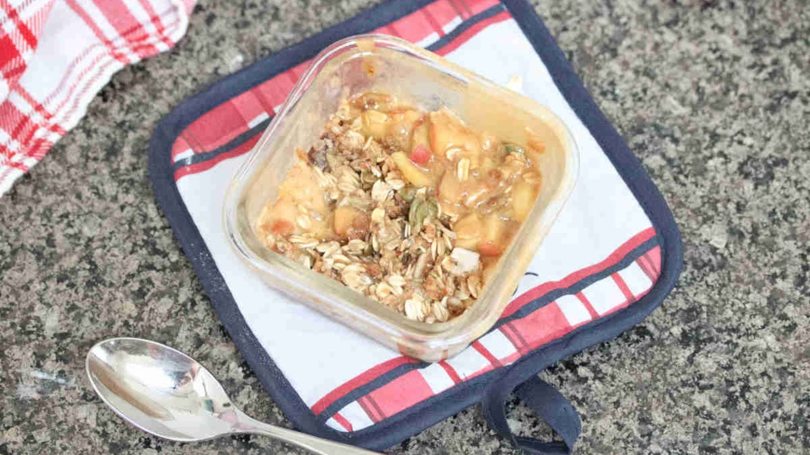 Protein apple crumble with oat topped in a single serve ramekin on a red and blue cooling pad.