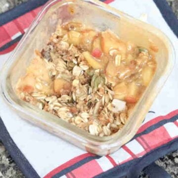Protein apple crumble with oat topped in a single serve ramekin on a hot pad.